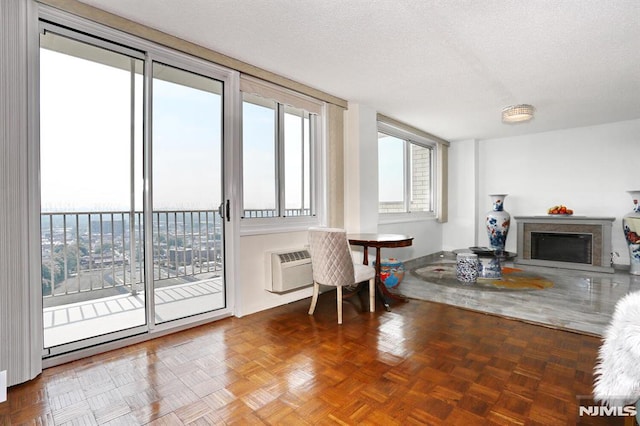 interior space featuring a wall mounted air conditioner, a textured ceiling, and parquet flooring