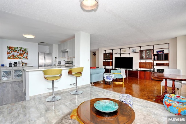 living room featuring a textured ceiling and light parquet floors