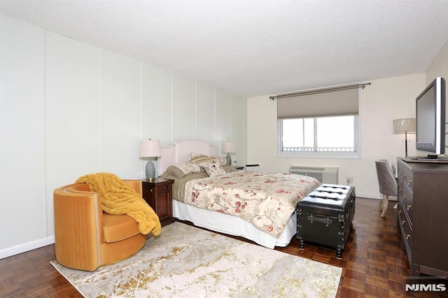 bedroom featuring dark parquet floors and a textured ceiling