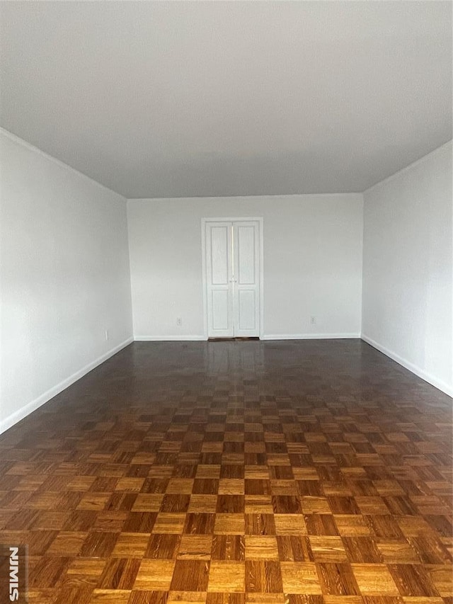 spare room with dark parquet flooring