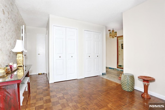 bedroom featuring multiple closets and dark parquet floors