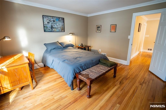 bedroom featuring light hardwood / wood-style flooring and ornamental molding