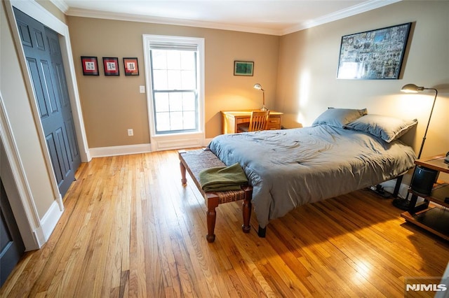 bedroom featuring a closet, light hardwood / wood-style floors, and ornamental molding