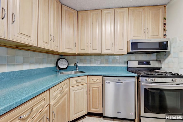 kitchen with sink, decorative backsplash, light tile patterned floors, light brown cabinetry, and stainless steel appliances