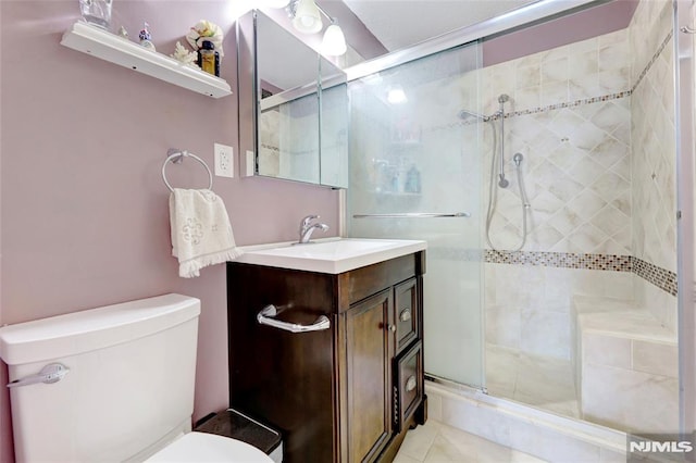 bathroom featuring tile patterned floors, vanity, toilet, and an enclosed shower