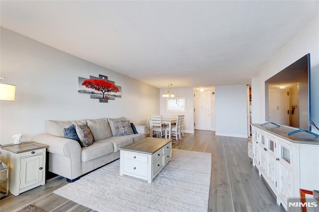 living room with a notable chandelier and light wood-type flooring