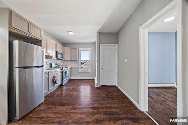 kitchen with decorative backsplash, dark hardwood / wood-style floors, appliances with stainless steel finishes, and a baseboard heating unit