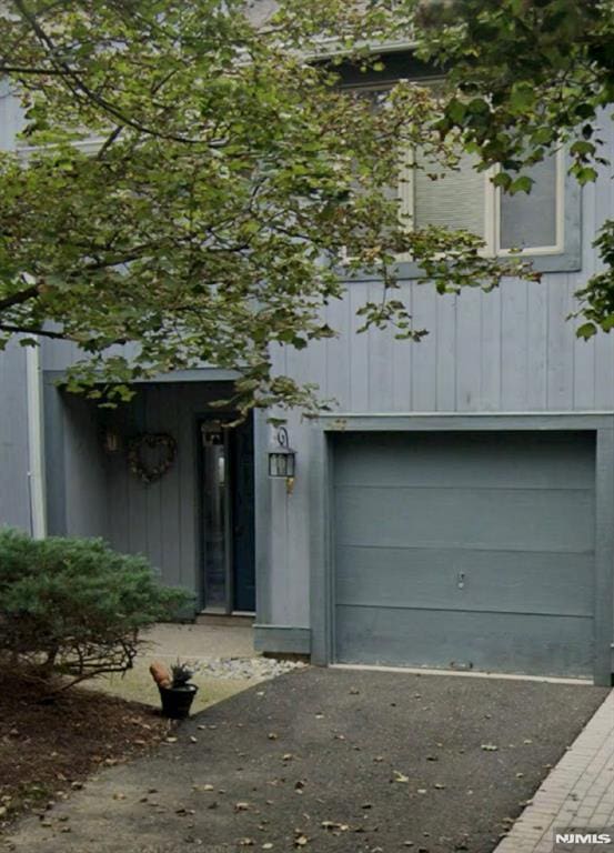 doorway to property with a garage and driveway