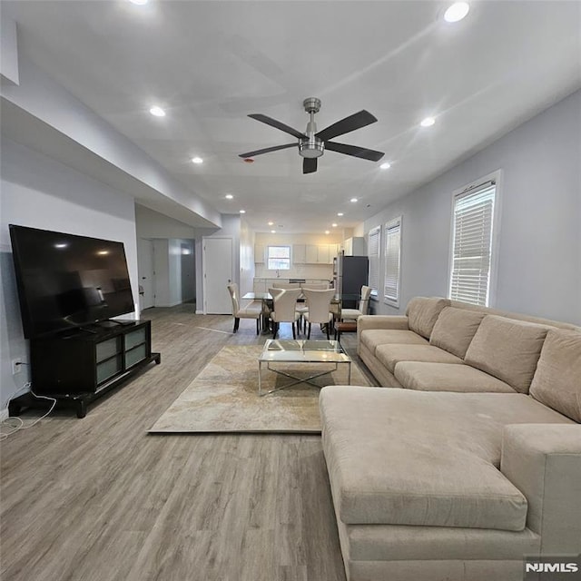 living room with light wood-type flooring and ceiling fan