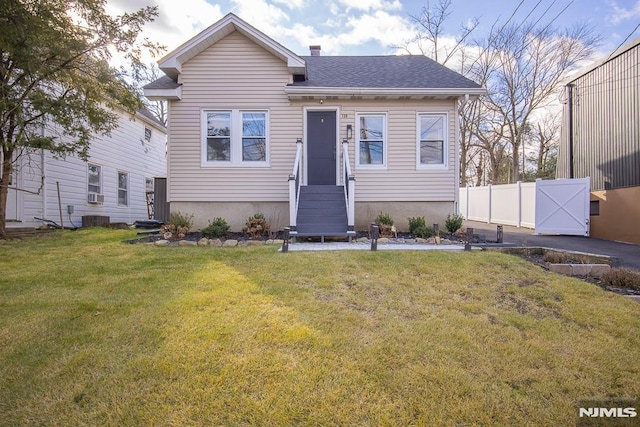 view of front of property with a front lawn and central AC unit