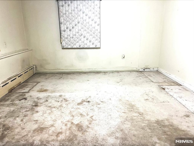 empty room with concrete floors and a baseboard radiator