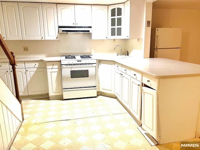 kitchen featuring kitchen peninsula, white cabinetry, sink, and white appliances