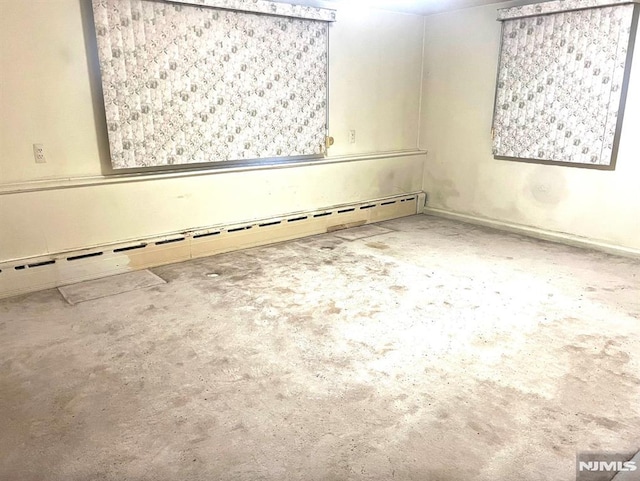 empty room with concrete floors and a baseboard heating unit