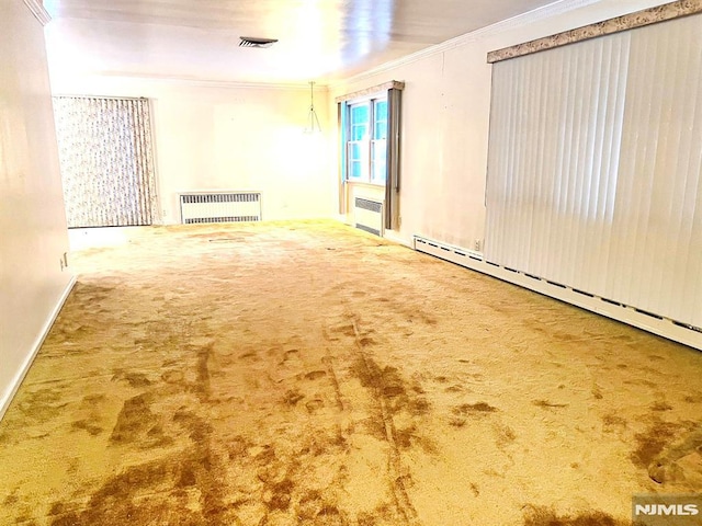 empty room featuring carpet, ornamental molding, radiator, and a baseboard radiator