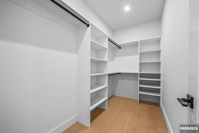 spacious closet with light hardwood / wood-style floors