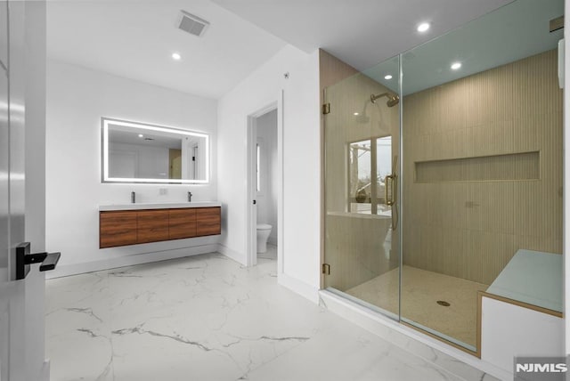 bathroom featuring vanity, toilet, and a shower with door