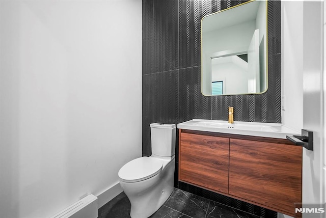 bathroom featuring vanity, toilet, and baseboard heating