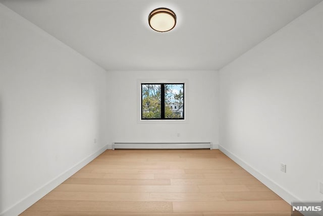 spare room with light hardwood / wood-style flooring and a baseboard radiator