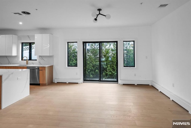 kitchen featuring dishwasher, white cabinets, and plenty of natural light