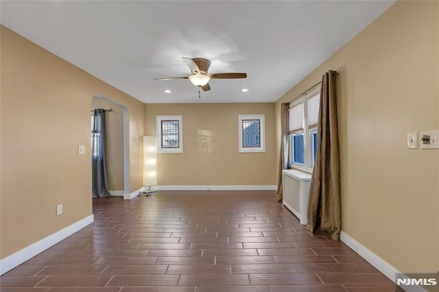 unfurnished room with ceiling fan and radiator heating unit