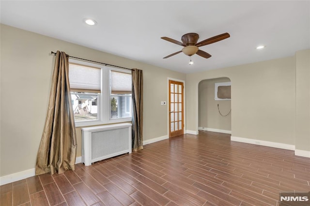 spare room with hardwood / wood-style floors, ceiling fan, and radiator heating unit