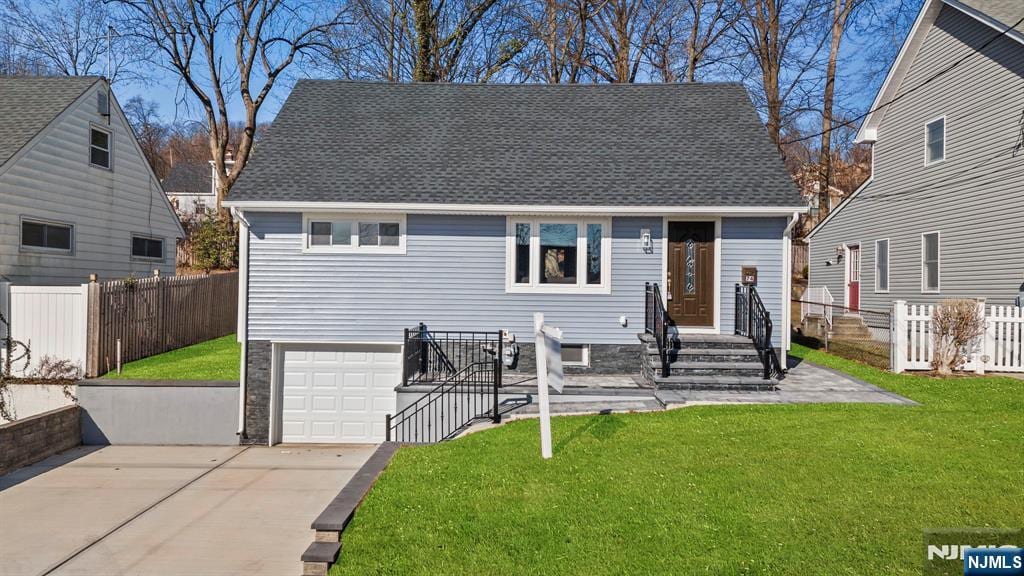 bungalow featuring a garage and a front lawn