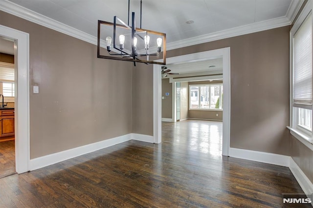 unfurnished dining area featuring crown molding, sink, dark wood-type flooring, and a notable chandelier