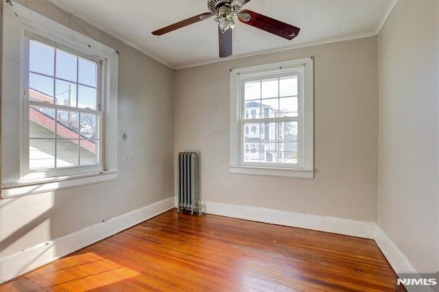 unfurnished room featuring crown molding, radiator heating unit, ceiling fan, and wood-type flooring