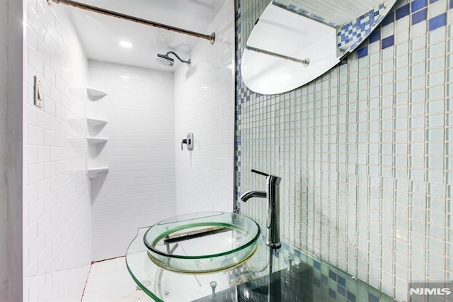 bathroom featuring a shower and tile walls