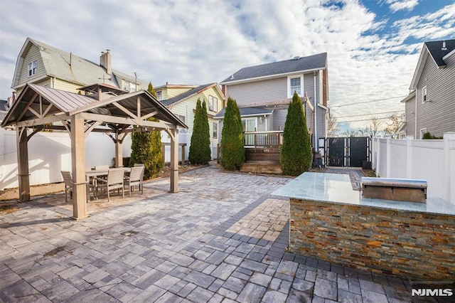 view of patio / terrace with a gazebo, exterior bar, and an outdoor kitchen