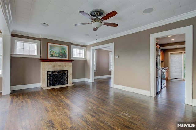 unfurnished living room with a tiled fireplace, ceiling fan, dark hardwood / wood-style flooring, and ornamental molding