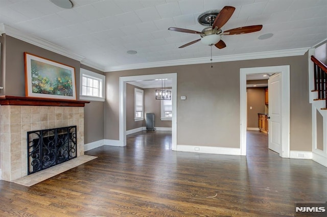 unfurnished living room featuring ceiling fan with notable chandelier, dark hardwood / wood-style floors, crown molding, and a tile fireplace