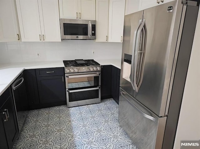 kitchen with stainless steel appliances, white cabinetry, and tasteful backsplash