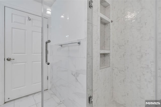 bathroom featuring a shower with shower door