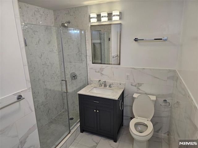 bathroom with walk in shower, vanity, toilet, and tile walls