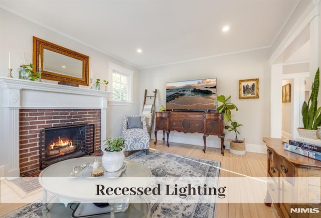 living room with a fireplace, hardwood / wood-style flooring, and ornamental molding