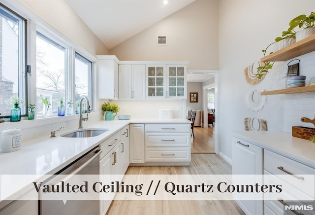 kitchen featuring white cabinetry, sink, dishwasher, high vaulted ceiling, and light wood-type flooring