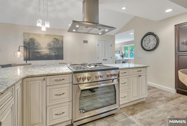 kitchen featuring decorative light fixtures, cream cabinetry, stainless steel stove, and island exhaust hood