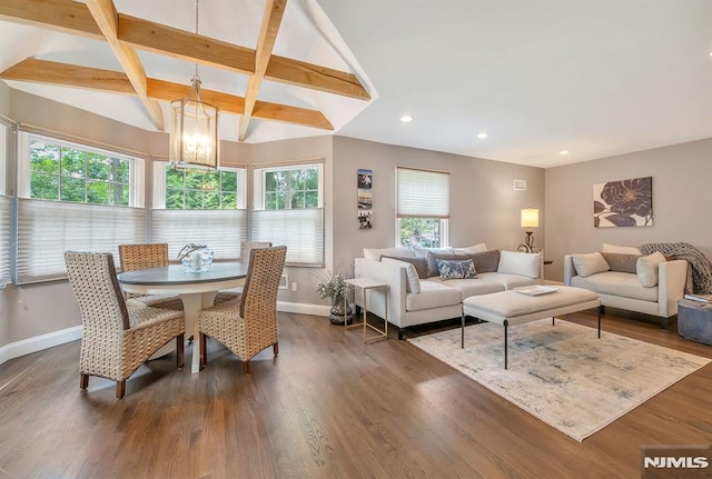 dining space with vaulted ceiling with beams, dark hardwood / wood-style flooring, a notable chandelier, and a healthy amount of sunlight