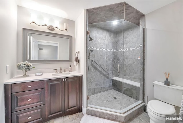 bathroom featuring vanity, toilet, and an enclosed shower