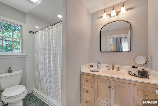 bathroom featuring toilet, vanity, and a shower with shower curtain