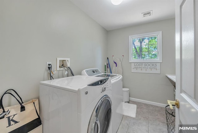 clothes washing area featuring washing machine and clothes dryer and light tile patterned floors