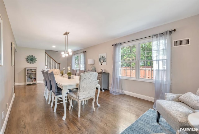 dining area featuring hardwood / wood-style flooring and a chandelier