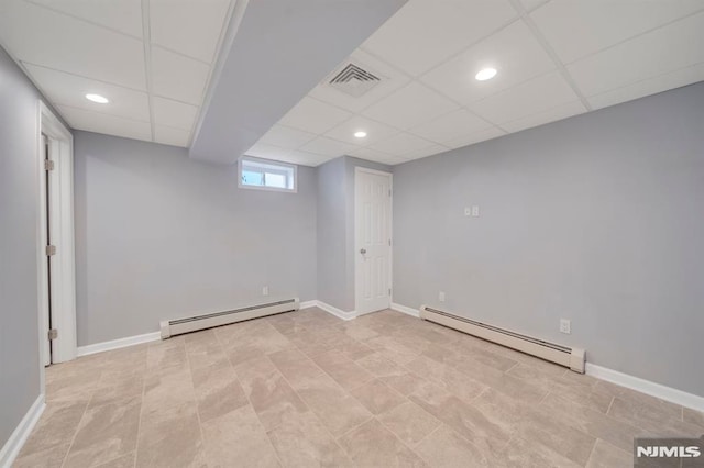 basement with baseboard heating and a drop ceiling