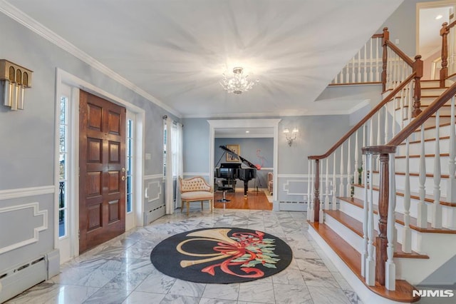 foyer featuring a notable chandelier, ornamental molding, and a baseboard heating unit