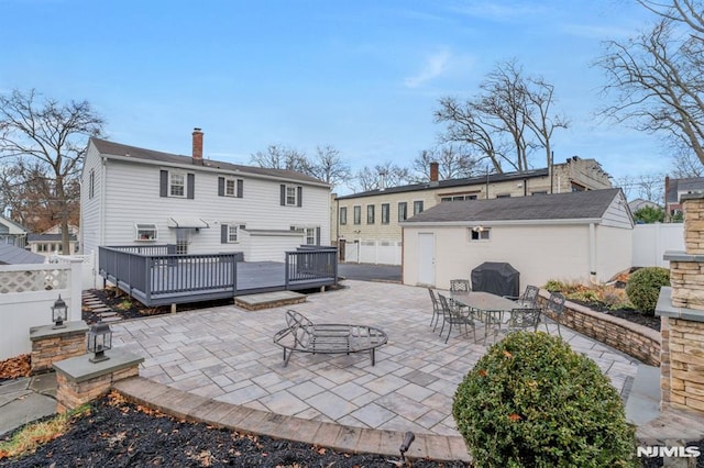 rear view of house featuring a patio area, an outbuilding, and a deck