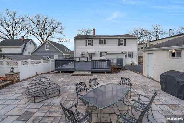 rear view of property featuring a deck and a patio area