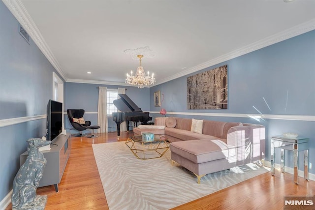 living room featuring an inviting chandelier, ornamental molding, and light hardwood / wood-style flooring