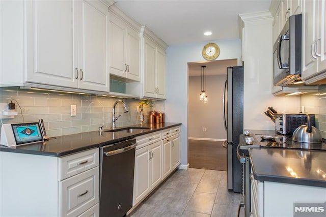 kitchen with sink, white cabinets, light tile patterned floors, hanging light fixtures, and appliances with stainless steel finishes