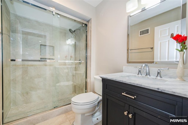 bathroom with vanity, tile patterned floors, a shower with shower door, and toilet